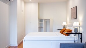A modern bedroom with a bed, bedside tables, a wardrobe, and a framed picture on the wall. - E: Sweeping Panoramic Terrace | Douro Views (Vila Nova de Gaia)