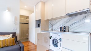 A compact apartment with a washing machine, a microwave, and a built-in oven. - G: Iconic Bridge View Balcony | Spacious 1BR Porto (Vila Nova de Gaia)