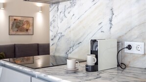 Eine moderne Küche mit Marmorarbeitsplatte, einer Kaffeemaschine und einer Steckdose.