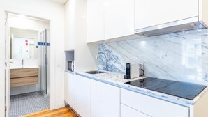 Eine moderne Küche mit Marmorfliesenspiegel, Edelstahlgeräten und Holzboden.