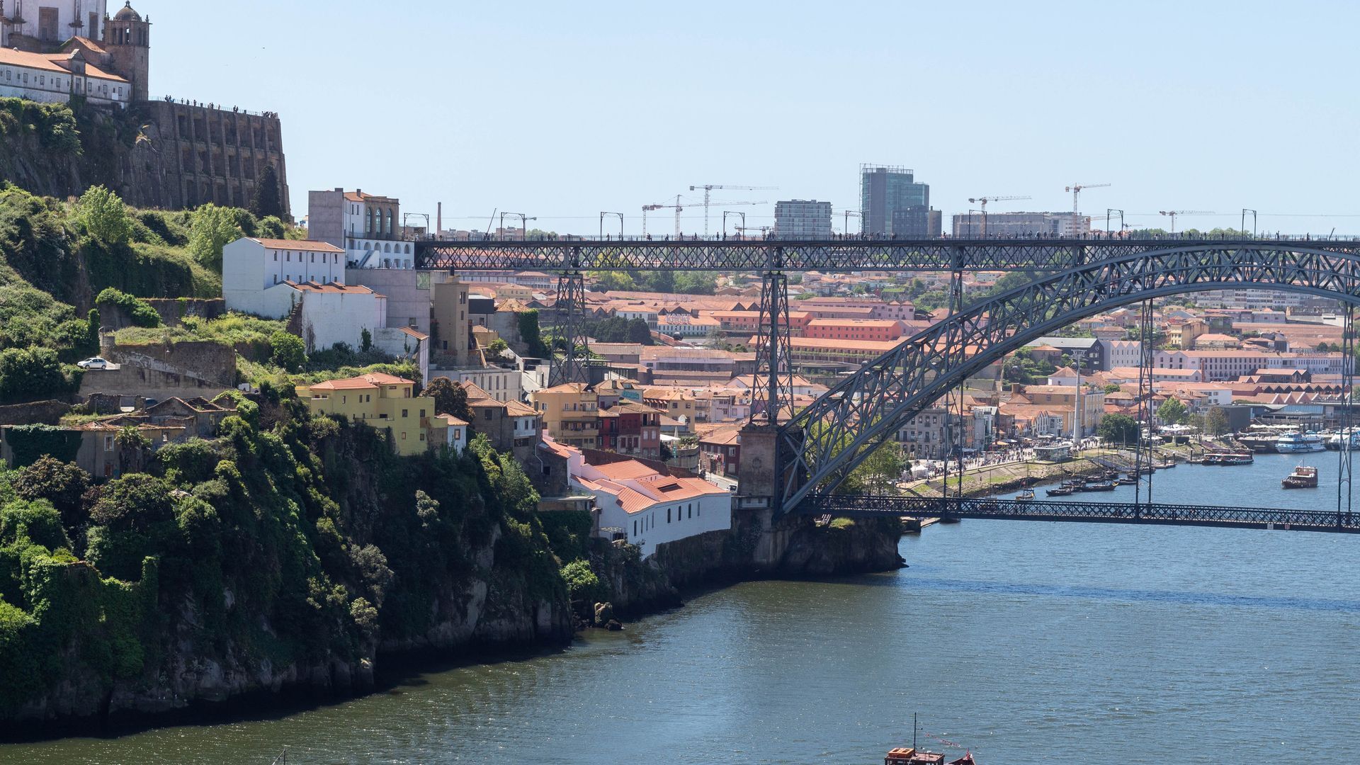 A bridge over a river with buildings on the opposite bank.