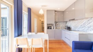 A modern kitchen with a marble countertop, a built-in microwave, and a toaster. - L: Douro & Bridge Views | Boutique 2BR Apartment (Vila Nova de Gaia)