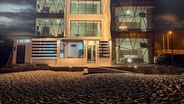 A modern building with a unique geometric design, featuring multiple floors and large windows. - Beach Front entire Private Building 32+ PAX (Montanita)