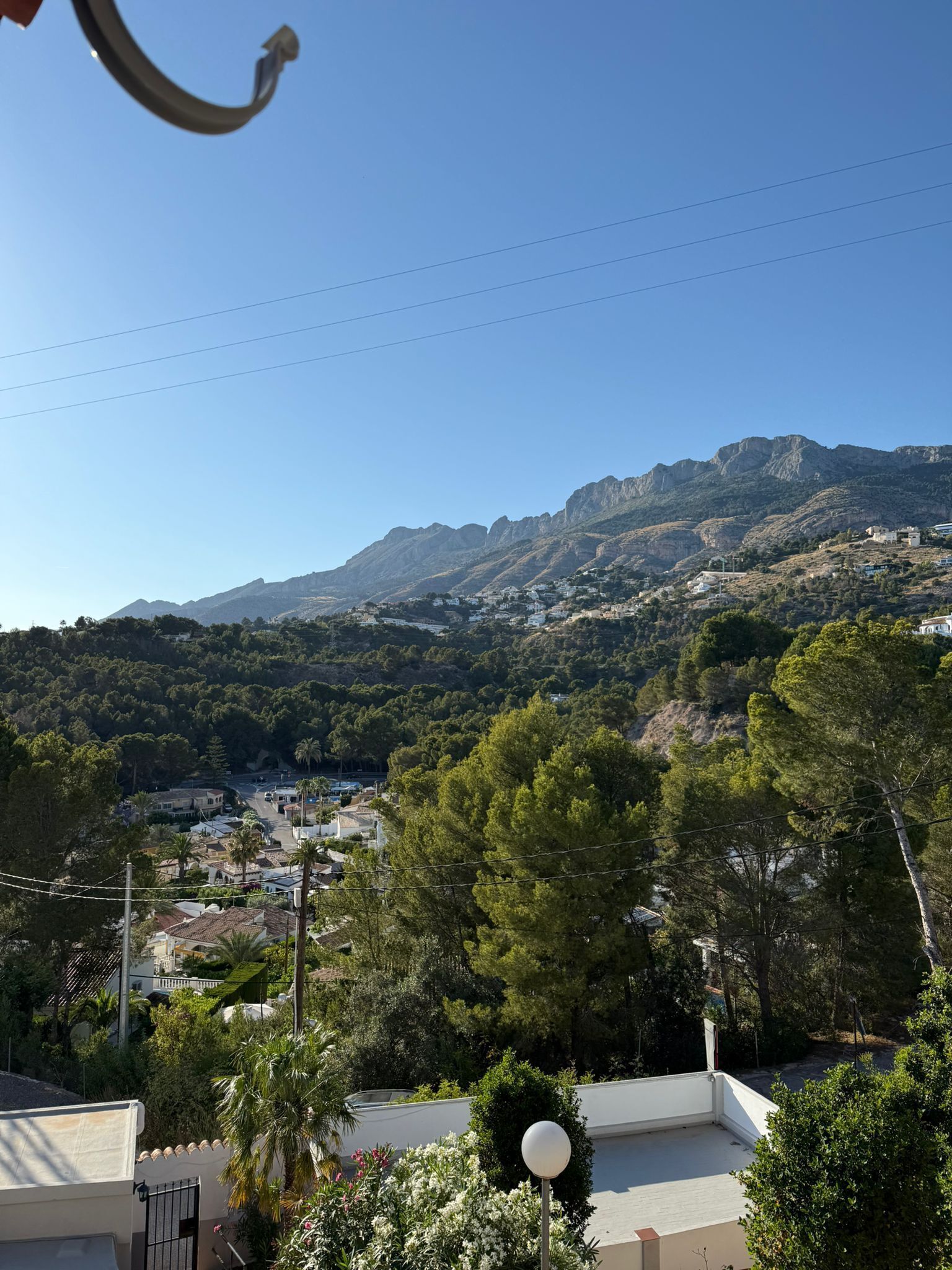 Un quartier résidentiel avec des maisons, des arbres et une montagne en arrière-plan.