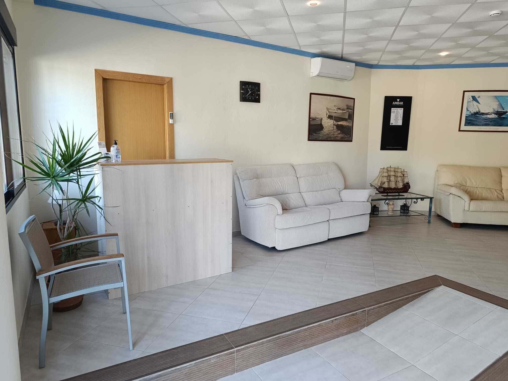Un salon propre et moderne, avec un canapé, un fauteuil et une table basse.