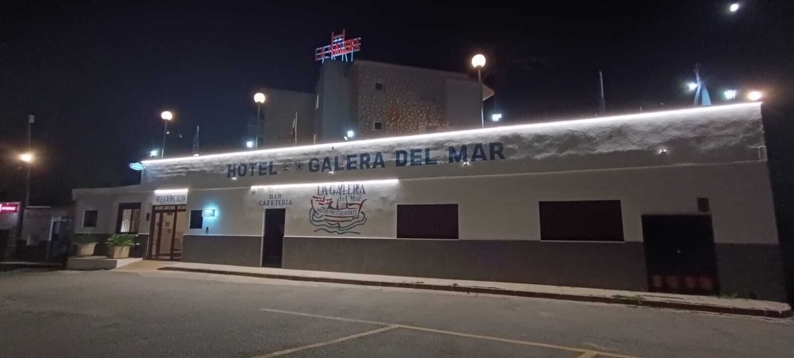 Un edificio con el rótulo 'HOTEL GALERA DEL MAR', un bar y una cafetería.