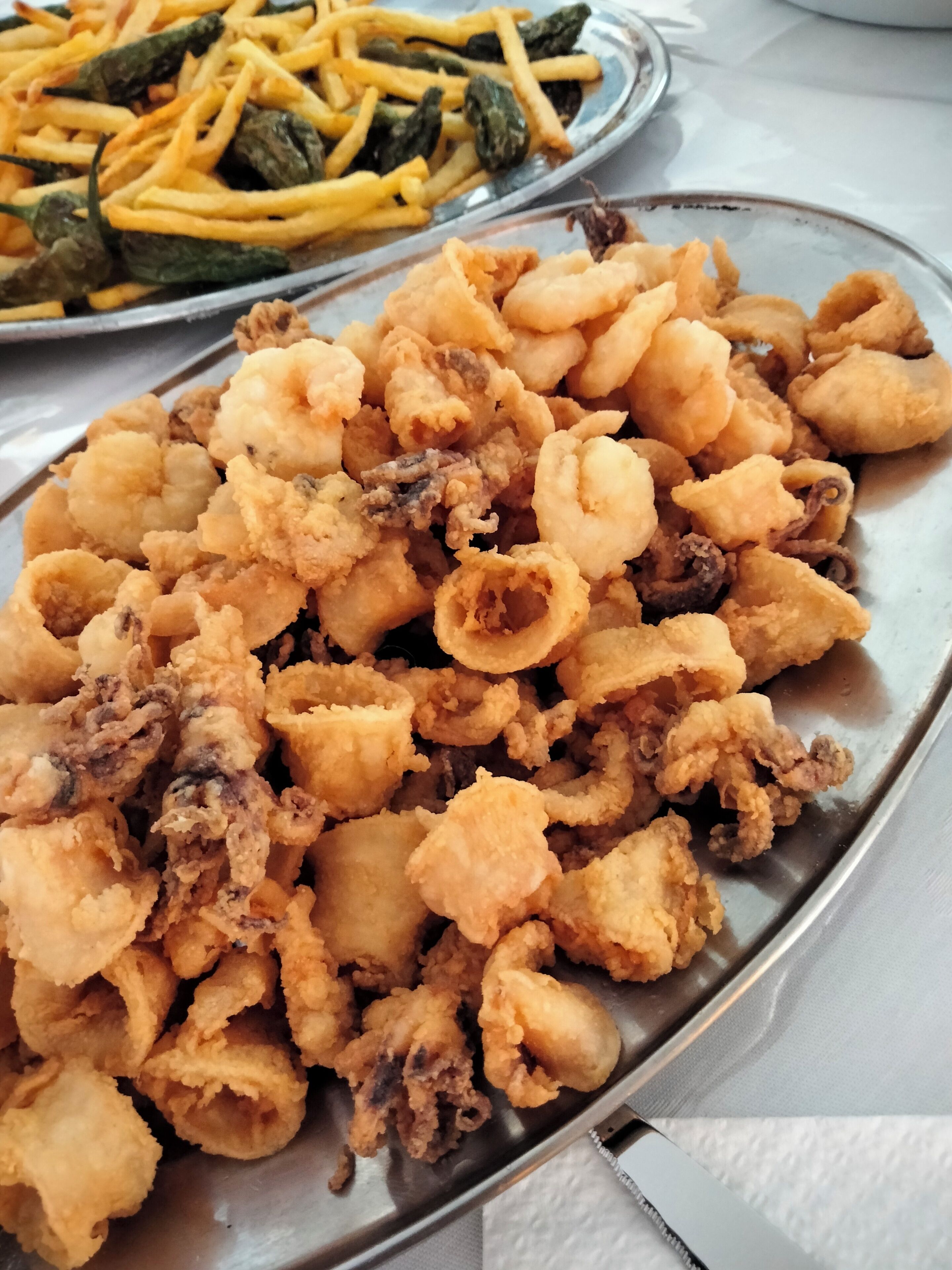 Un plato de calamares fritos y papas fritas.