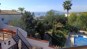 Un barrio residencial con piscina, una escalera y vistas al mar y a la montaña.