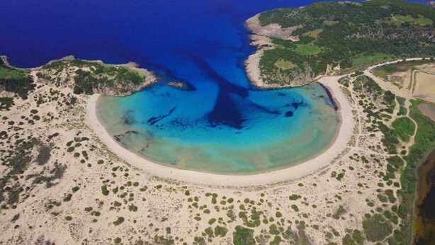 An aerial view of a coastal area with a large bay, sandy beaches, and green vegetation. - Taygetos Relaxing Cottage (Poliani)