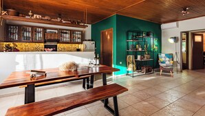 A spacious kitchen with wooden cabinets, a dining table, and a bench. - Taygetos Relaxing Cottage (Poliani)