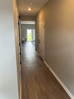 A hallway with a door leading to a room with a sliding glass door to the outside. - Keefer Creek A106 (Dogs Welcome!) (Fort Wayne)