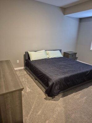 A bedroom with a bed, a nightstand, and a dresser. - Keefer Creek A106 (Dogs Welcome!) (Fort Wayne)