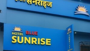 A hotel named 'Hotel Sunrise' with a blue facade and a sign indicating 'Hotel Sunrise' and 'Hotel Sunrise Free.' - Hotel Blue Sunrise near Mumbai Airport (Mumbai)