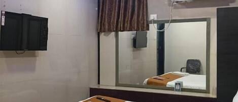 Ein Hotelzimmer mit einem Bett, einem Spiegel, einer Klimaanlage und einer Decke mit blauer Beleuchtung.