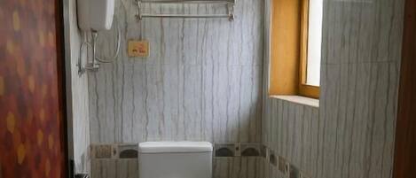 A compact bathroom with a toilet, sink, and a small window.