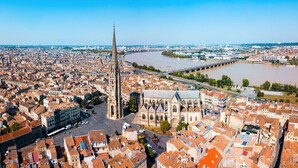 An aerial view of a city with a prominent cathedral, a river, and a bridge. - L'Ô en Couleur - Au coeur de Bordeaux (Bordeaux)