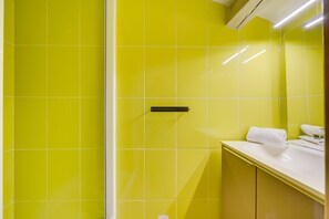 A bathroom with yellow tiles, a white sink, and a mirror. - L'Ô en Couleur - Au coeur de Bordeaux (Bordeaux)