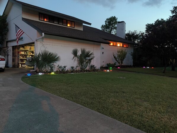 A two-story building with a garage, a flag, and a well-maintained lawn.