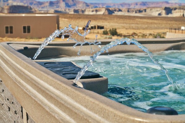 A hot tub with water jets in a desert landscape.