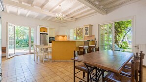 A spacious kitchen with a large island, open-plan layout, and a dining area with a wooden table and chairs. - Le Mas des Trois Sources - Grand jardin (Gignac)
