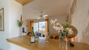Un coin repas avec une table en bois, une bouteille de vin, un verre et un globe terrestre.