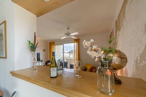 A dining area with a wooden table, wine bottle, glass, and a globe. - Le Thiou - Vue sur le château et la Visitation (Annecy)