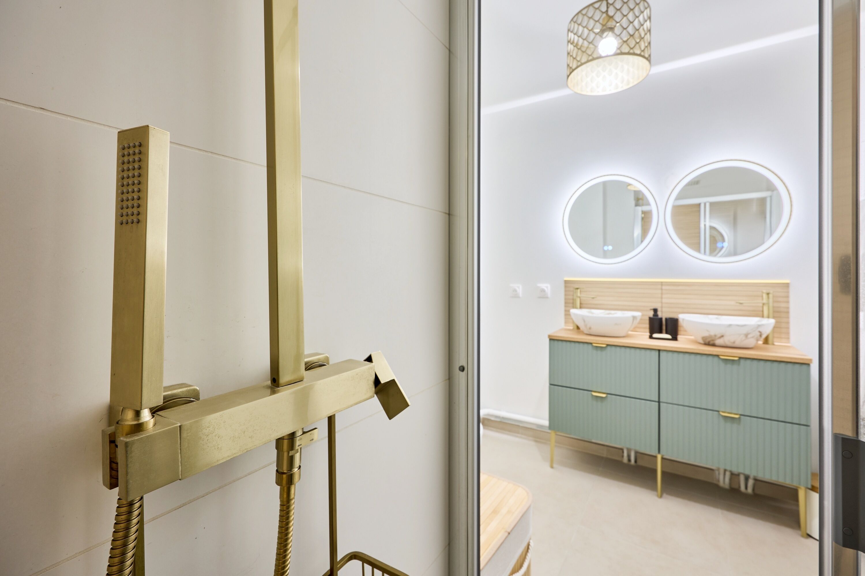 A modern bathroom with a glass shower enclosure, a wooden vanity with two sinks, and a mirror above the vanity.