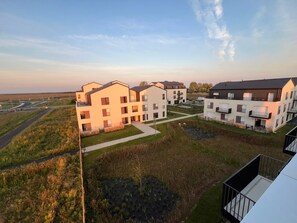 Un ensemble résidentiel comprenant plusieurs immeubles d’appartements, une cour intérieure et une route en arrière-plan.