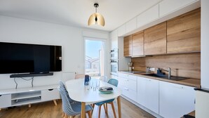 Una cucina moderna con mobili bianchi, un piano di lavoro in legno e un forno integrato.