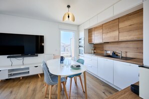 Eine moderne Küche mit weißen Schränken, einer Holz Arbeitsplatte und einem eingebauten Backofen.