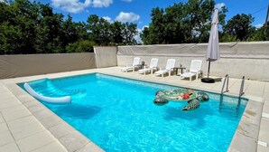 A rectangular swimming pool with clear blue water, surrounded by a tiled deck. - L'Oasis de SaBen - Piscine Privée (Belfort-du-Quercy)