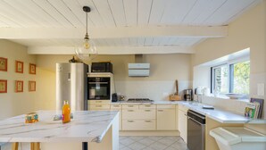 Una cocina moderna con encimera de mármol, electrodomésticos de acero inoxidable y una ventana que proporciona luz natural.