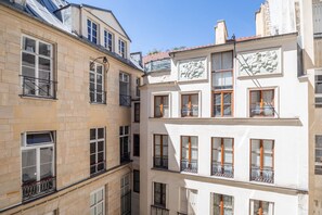 A multi-story building with stone and plaster facades, multiple balconies, and a clear sky. - Saint Michel Seine Loft (Paris)