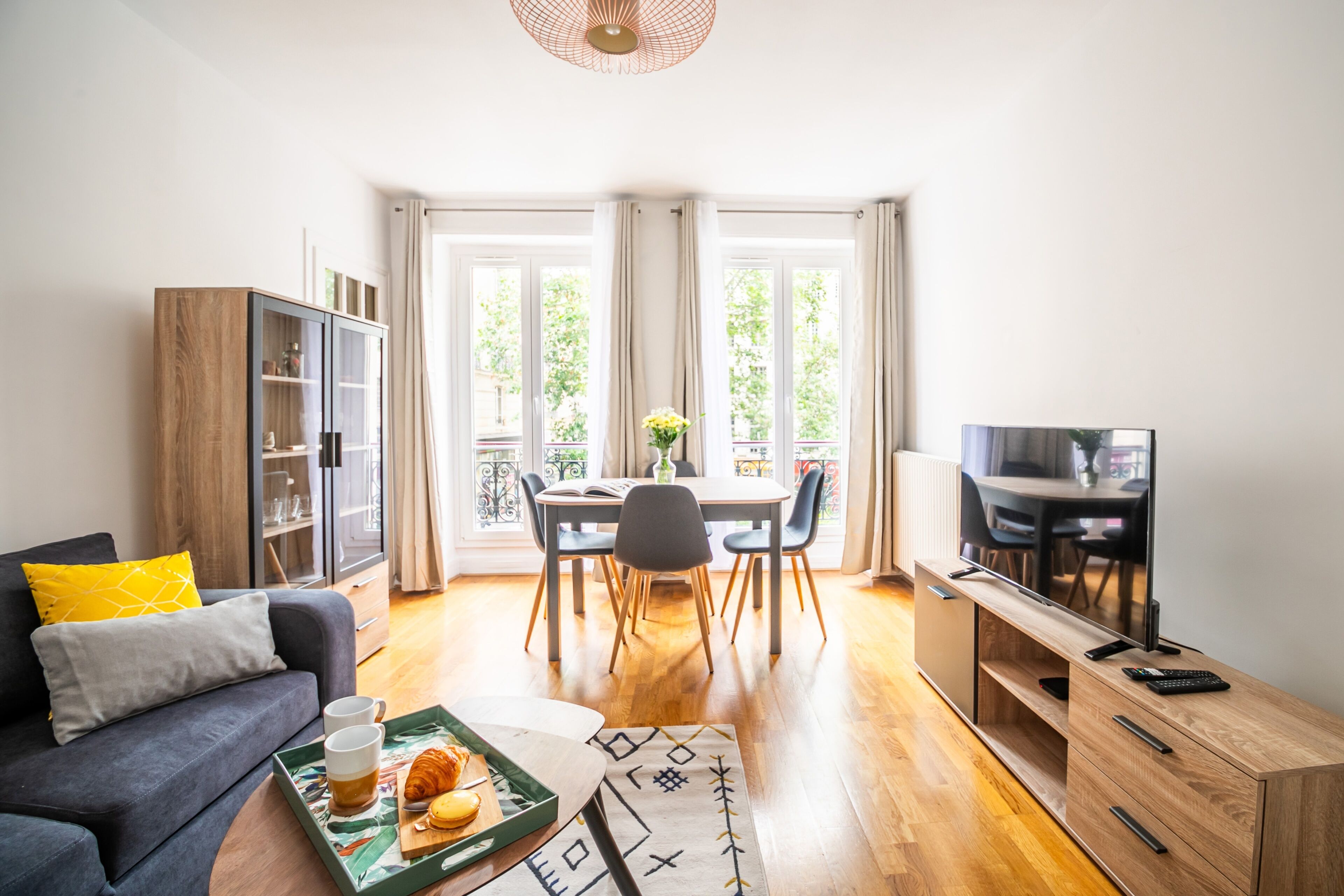 A modern living room with a sofa, dining table, and TV.