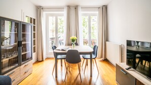 Ein Essbereich mit Tisch, Stühlen, einem Schrank und einem Fernseher.