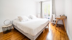 Ein Schlafzimmer mit einem Bett, einem Schreibtisch und einem Sessel.