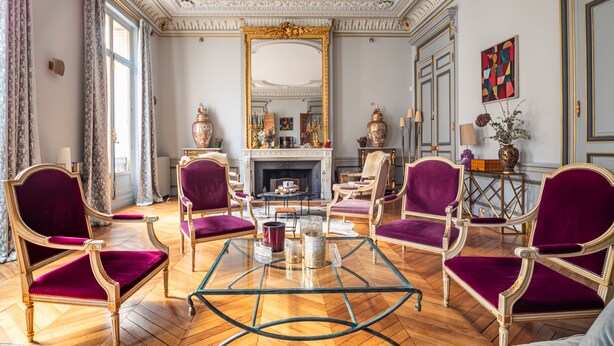 A room with a fireplace, ornate furniture, and a large mirror.