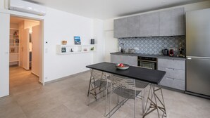 A modern kitchen with a dining area, built-in cabinets, and a refrigerator. - Tour Eiffel Loft - One Bedroom Apartment, Sleeps 3 (Paris)