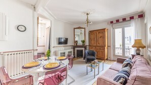 Ein Wohnzimmer mit Essbereich, Kamin, Fernseher und einer Couch.