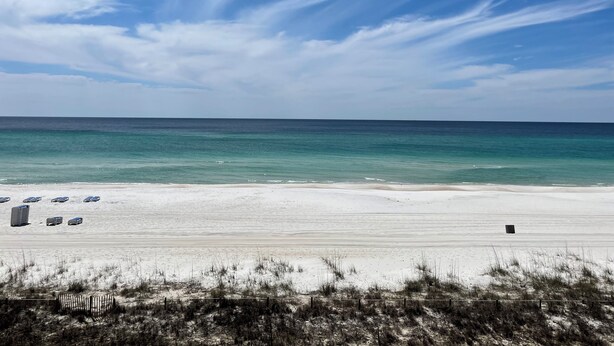 A beach with a clear sky, a sandy shore, and a few parked vehicles. - updated 2-bedroom, 2 bath, sleeps 6 family friendly condo. Many extras. (Gulf Shores)