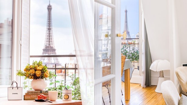 Habitació amb vista a la Torre Eiffel, un ram de flors grogues, un borsa de Chanel i un llibre de Vignes.