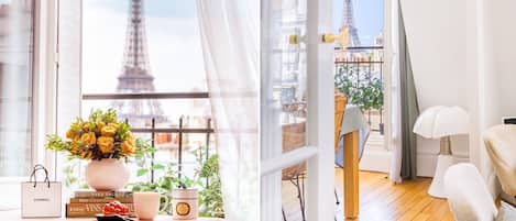 Une chambre avec vue sur la Tour Eiffel, un vase rempli de fleurs jaunes, un sac Chanel et un livre de Vignes.