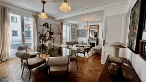Ein modernes Wohnzimmer mit Glastisch, Sofas und Kamin.