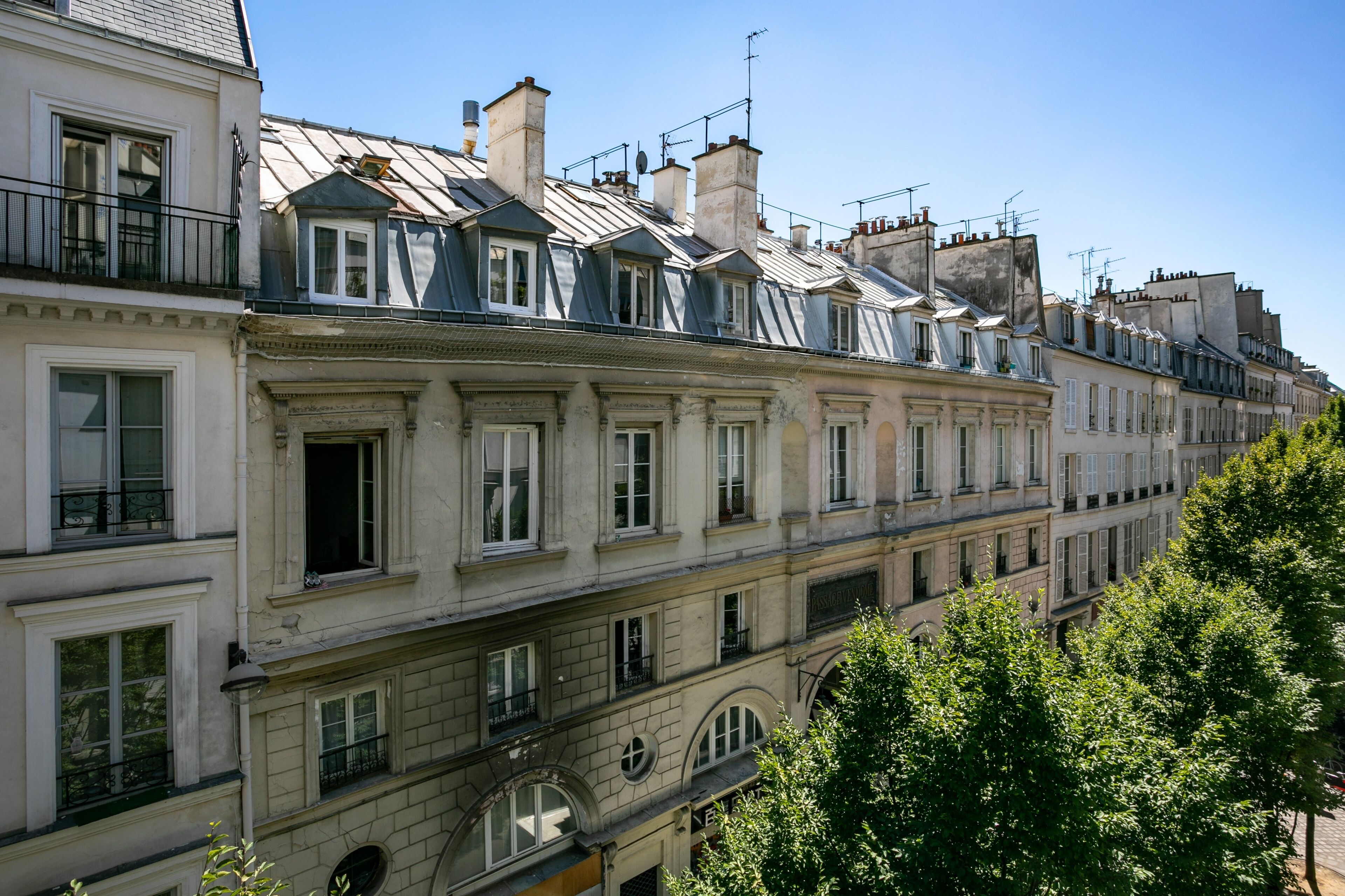 A row of European-style buildings with balconies, large windows, and a clear sky.