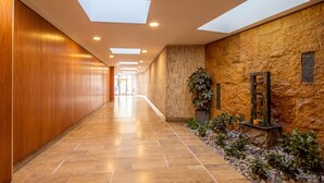 A corridor with a wooden wall, stone wall, and a tiled floor. - Tour Eiffel Grenelle (Paris)