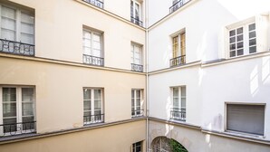 A multi-story building with balconies, large windows, and an arched entrance. - Quartier Latin Loft Maubert (Paris)