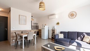 Una sala de estar moderna con sofá, mesa de centro y comedor.