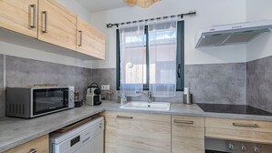 Una cocina moderna con microondas, tostadora, fregadero, lavavajillas y horno.