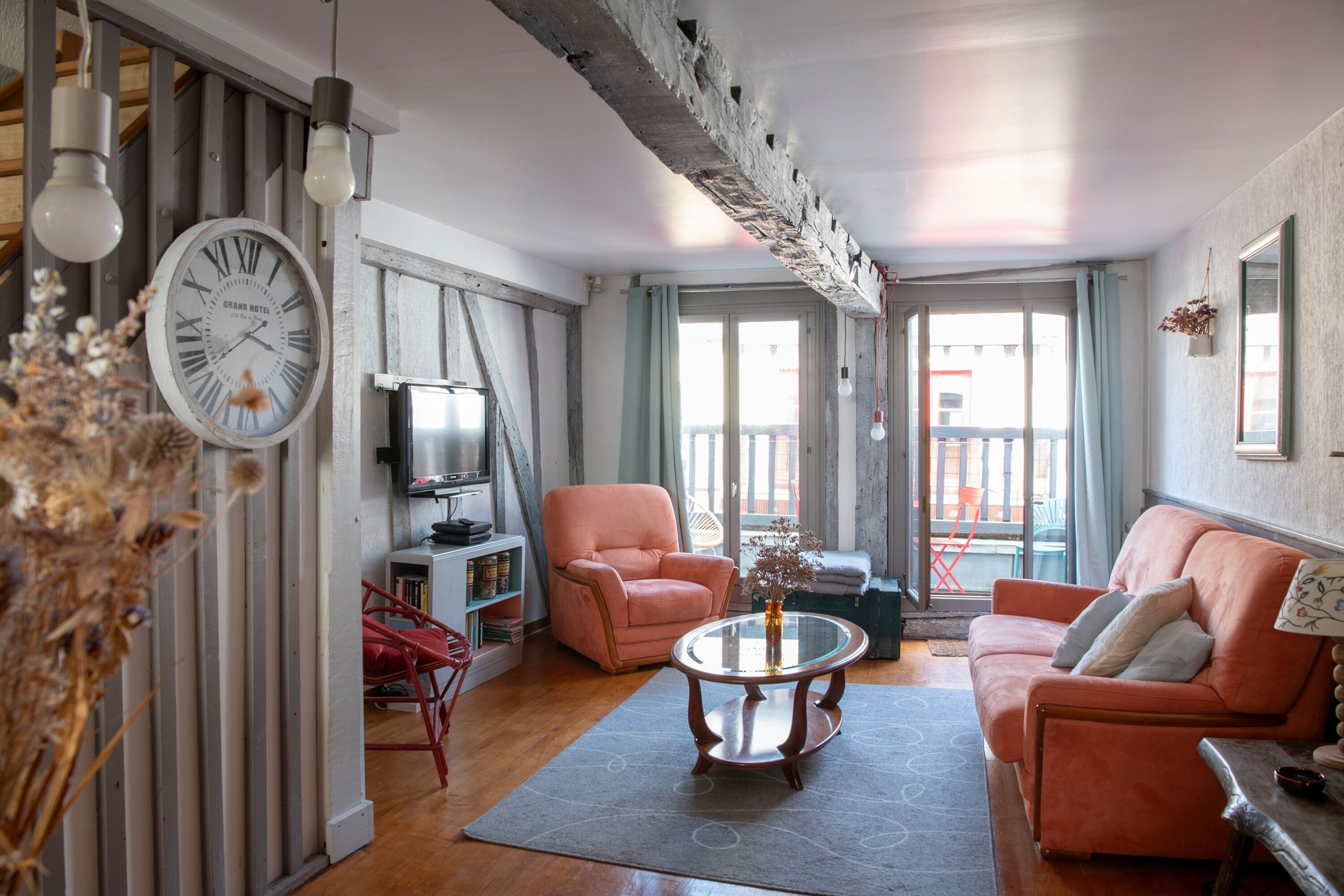 Ein Wohnzimmer mit einer Couch, einem Sessel und einem Glastisch.