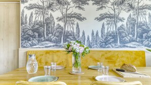 A dining table set with plates, glasses, a vase with flowers, and a loaf of bread. - L'Atelier de Sèvres - 2 places de parking (Boulogne-Billancourt)